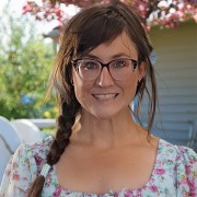 Smiling woman with glasses and long dark hair in a single braid